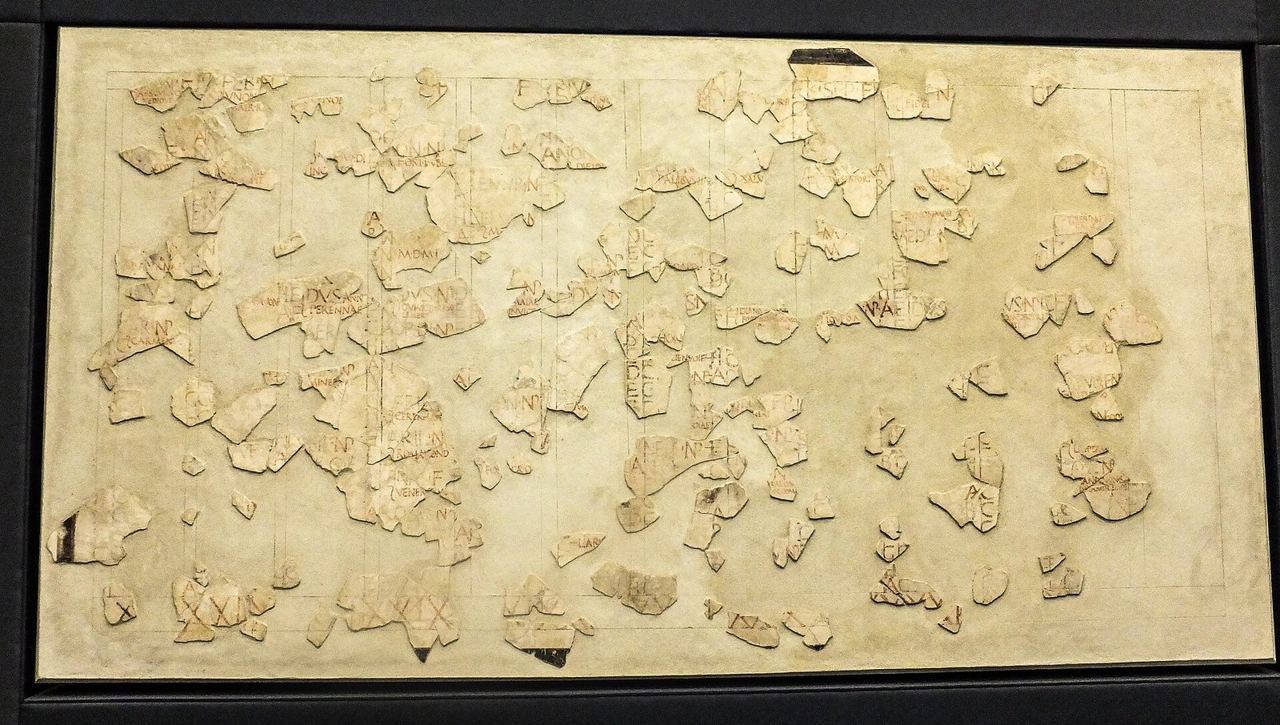 Hundreds of fragments of a painted Roman wall calendar reassembled on a pale panel
