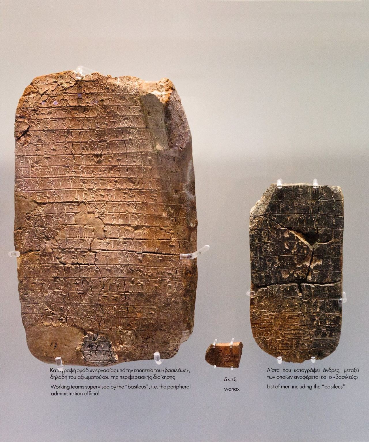 Two clay tablets incised with rows of Linear B signs in a museum case
