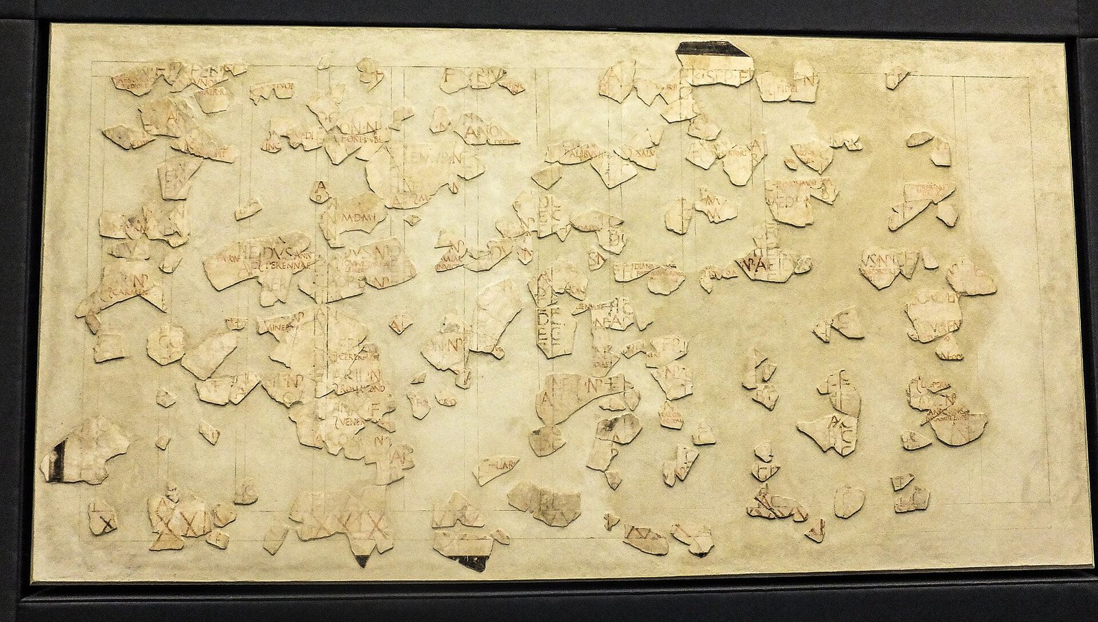 Hundreds of fragments of a painted Roman wall calendar reassembled on a pale panel